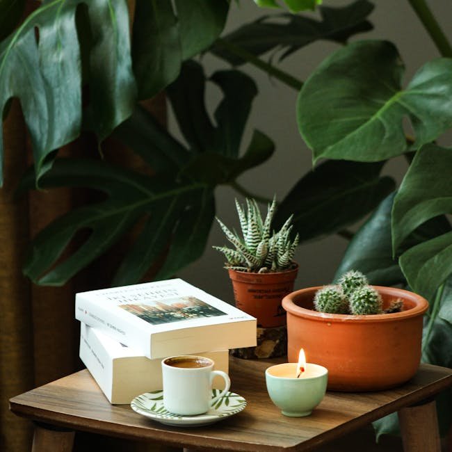 A cozy home interior with books, houseplants, and candlelight on a wooden table.